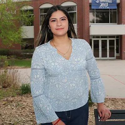 a transfer student poses for a photo outside the student union